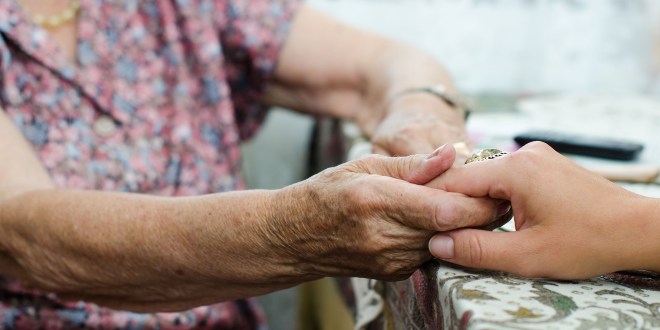 A young hand holding an old pair of hands